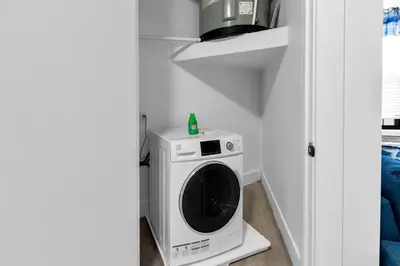 a washer and dryer in a corner of a room at Blue Bliss Indoor Pool, FREE Parking, Near NYC in Elizabeth