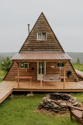 a large wooden house with a large porch and a bench at Rustic Escape UTV, Tub, Trails & Fire Pit 25 acre in Roscoe
