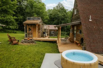 a hot tub on a deck next to a house at Rustic Escape UTV, Tub, Trails & Fire Pit 25 acre in Roscoe