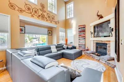 a living room with a gray couch and a fireplace at Theater and Game Room at Trenton Area Home in Edgewood Park