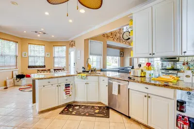 a large kitchen with white cabinets and a tile floor at Theater and Game Room at Trenton Area Home in Edgewood Park