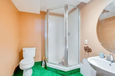 a bathroom with a shower and a toilet and a sink at Theater and Game Room at Trenton Area Home in Edgewood Park