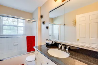 a bathroom with a sink and a toilet and a mirror at Theater and Game Room at Trenton Area Home in Edgewood Park