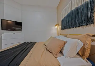 a bedroom with a bed with pillows and a tv at Upper West Side Furnished 1 Bedroom Apartment, June to Aug 90 days stay required in New York