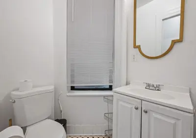 a white bathroom with a toilet and a sink at Upper West Side Furnished 1 Bedroom Apartment, June to Aug 90 days stay required in New York