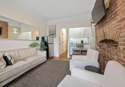 a living room with a couch and a brick wall at Upper West Side Furnished 1 Bedroom Apartment, June to Aug 90 days stay required in New York