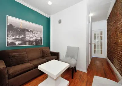 a living room with a brown couch and a white table at Furnished 2 Bedroom Apartment Midtown West NYC, June To Aug 90 Days Stay Required in New York