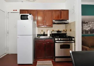 a kitchen with a stove and a refrigerator at Furnished 2 Bedroom Apartment Midtown West NYC, June To Aug 90 Days Stay Required in New York