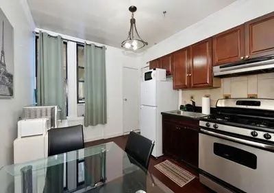 a kitchen with a glass table and a refrigerator at Furnished 2 Bedroom Apartment Midtown West NYC, June To Aug 90 Days Stay Required in New York