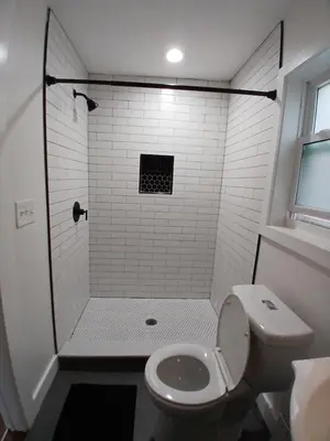 a white bathroom with a shower and a toilet at Monthly Stays - 2BR Apt in Bloomfield - 8 Min Walk from NJ Transit in Bloomfield