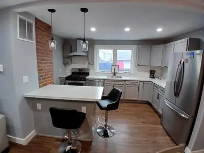 a kitchen with a refrigerator and two bar stools at Monthly Stays - 2BR Apt in Bloomfield - 8 Min Walk from NJ Transit in Bloomfield
