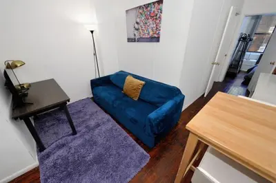 a living room with a blue couch and a table at Furnished Apartment Room Rental In NYC, June To Aug 90 Days Stay Required in New York