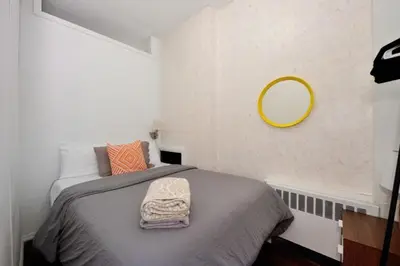 a bedroom with a bed with a mirror on the wall at Furnished Apartment Room Rental In NYC, June To Aug 90 Days Stay Required in New York