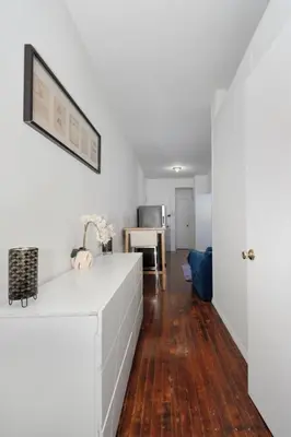 a kitchen with white walls and a wooden floor at Furnished Apartment Room Rental In NYC, June To Aug 90 Days Stay Required in New York