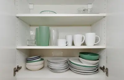 a cabinet filled with plates and cups and dishes at Furnished Apartment Room Rental In NYC, June To Aug 90 Days Stay Required in New York