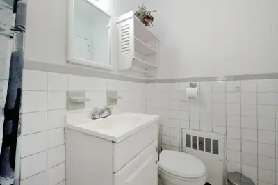 a white bathroom with a sink and a toilet at Furnished Apartment Room Rental In NYC, June To Aug 90 Days Stay Required in New York