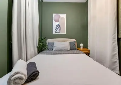 a bedroom with a white bed and a green wall at Prime Murray Hill 2 BR Gem, June To Aug 90 Days Stay Required in New York