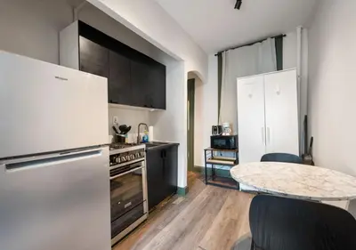 a kitchen with a white refrigerator and a table at Prime Murray Hill 2 BR Gem, June To Aug 90 Days Stay Required in New York