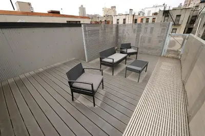a deck with four chairs and benches on a rooftop at Spacious 2BR 2BA with Rooftop Walk to Times Square, June To Aug 90 Days Stay Required in New York
