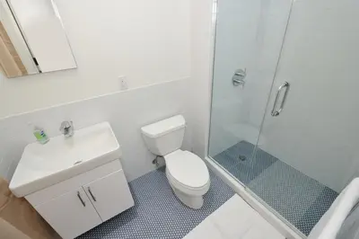 a bathroom with a toilet and a sink and a shower at Spacious 2BR 2BA with Rooftop Walk to Times Square, June To Aug 90 Days Stay Required in New York