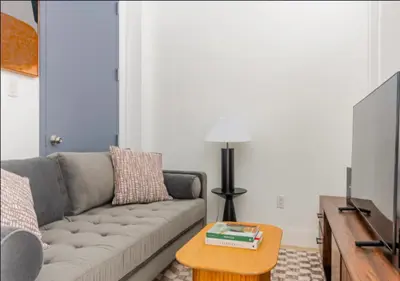 a living room with a couch and a table at Murray Hill 1 Bed Furnished Apt in New York