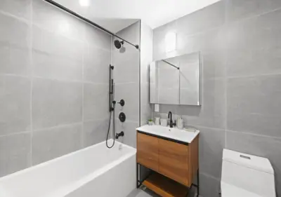 a bathroom with a sink and a tub and a toilet at Murray Hill 1 Bed Furnished Apt in New York
