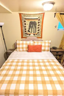 a bedroom with a bed with a checkered blanket at Charming Private 1BR Apartment with Easy NYC Access in Maplewood