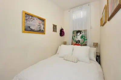 a bedroom with a white bed and a painting on the wall at Prime Location Murray Hill! Grand Central Station!, June To Aug 90 Days Stay Required in New York