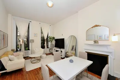 a living room with white furniture and a fireplace at Prime Location Murray Hill! Grand Central Station!, June To Aug 90 Days Stay Required in New York