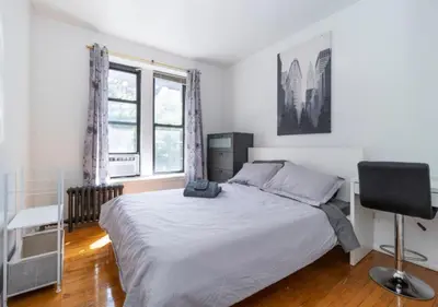 a bedroom with a bed and a desk and two windows at Murray Hill and Kips Bay! Amazing 1BR for 2! in New York