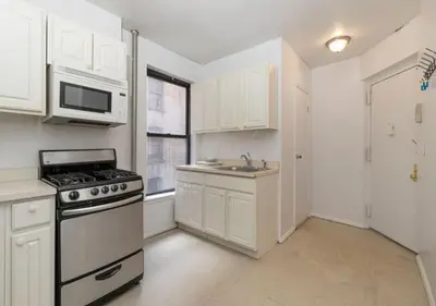 a kitchen with white cabinets and a stove at Murray Hill and Kips Bay! Amazing 1BR for 2! in New York