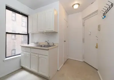 a white kitchen with a sink and a window at Murray Hill and Kips Bay! Amazing 1BR for 2! in New York