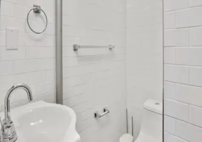 a white bathroom with a sink and a shower at Amazing Studio in Kips Bay! in New York