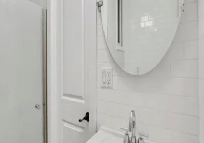 a white bathroom with a sink and a mirror at Amazing Studio in Kips Bay! in New York