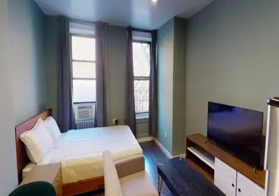 a bedroom with a bed and a flat screen tv at Amazing Studio in Kips Bay! in New York