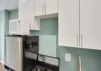 a microwave on top of a refrigerator in a kitchen at Amazing Studio in Kips Bay! in New York