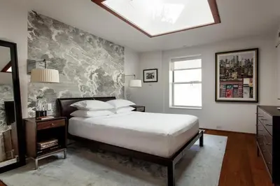 a bedroom with a large bed and a skylight at Roedonis SoHo in New York