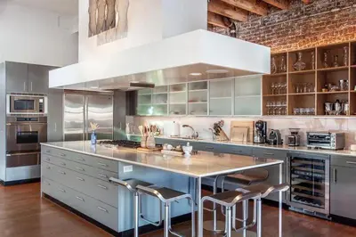 a large kitchen with a large counter with stools at Roedonis SoHo in New York