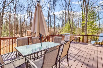 a patio with a table and an umbrella on a deck at Walk to Lake Harmony Family Retreat with Decks! in Albrightsville