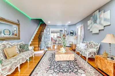 a living room with two couches and a staircase at 3 Mi to Penn Pet-Friendly Townhome in Yeadon! in Yeadon