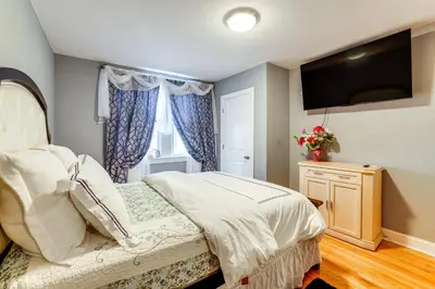 a bedroom with a bed and a flat screen tv at 3 Mi to Penn Pet-Friendly Townhome in Yeadon! in Yeadon