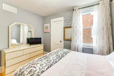 a bedroom with a bed and a mirror and a television at 3 Mi to Penn Pet-Friendly Townhome in Yeadon! in Yeadon