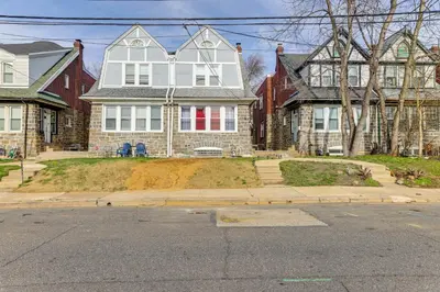 a large white house with a red door at 3 Mi to Penn Pet-Friendly Townhome in Yeadon! in Yeadon