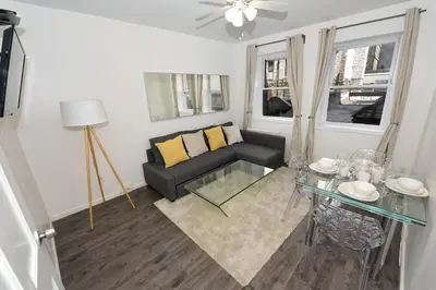 a living room with a couch and a glass table at Amazing 4 BR 1 BTH Laundry Dishwasher, June To Aug 90 Days Stay Required in New York