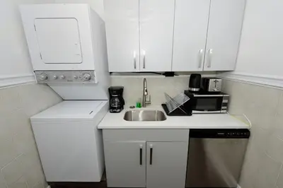 a white kitchen with a sink and a microwave at Amazing 4 BR 1 BTH Laundry Dishwasher, June To Aug 90 Days Stay Required in New York