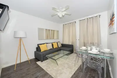 a living room with a couch and a glass table at Amazing 4 BR 1 BTH Laundry Dishwasher, June To Aug 90 Days Stay Required in New York