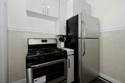a kitchen with a stove and a refrigerator at Amazing 4 BR 1 BTH Laundry Dishwasher, June To Aug 90 Days Stay Required in New York