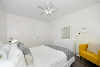 a white bedroom with a bed and a ceiling fan at Amazing 4 BR 1 BTH Laundry Dishwasher, June To Aug 90 Days Stay Required in New York