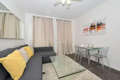 a living room with a couch and a glass table at Amazing 4 BR 1 BTH Laundry Dishwasher, June To Aug 90 Days Stay Required in New York