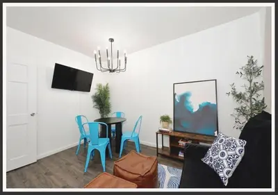 a living room with a table and blue chairs at Four Bedroom Prime Furnished Rental, June To Aug 90 Days Stay Required in New York